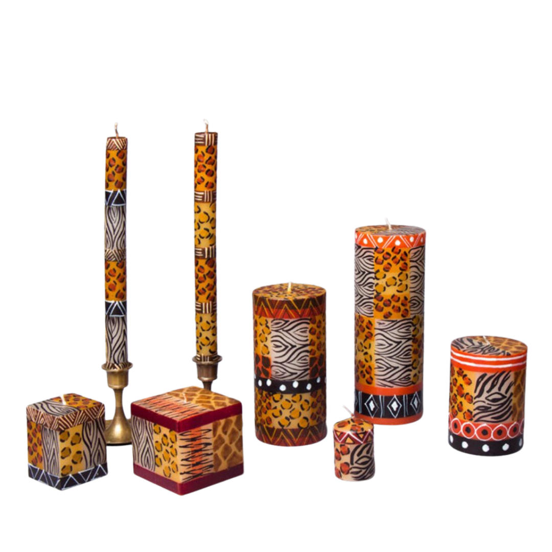 Animal Print candle collection. Hand poured and hand painted candles made in South Africa. Fair trade. Small & larger cube candle, taper candle pair, 3 pillar candles and votives.  Pattern is different animal prints with black & detail between the different animal prints.