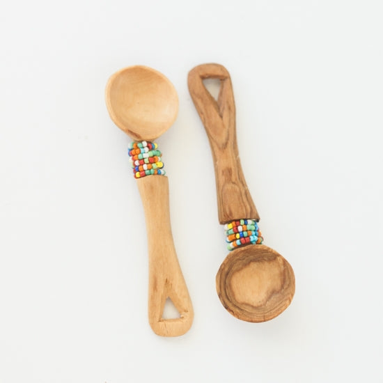 2 small wooden spoons with bead work just under the round head of the spoon. Approx. 4" long.  Hand made, fair trade.