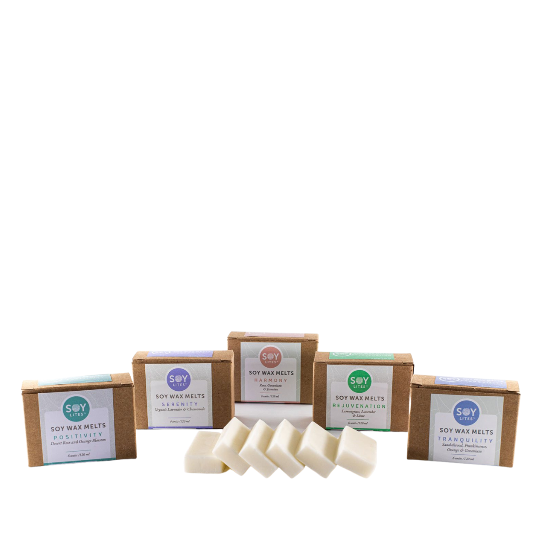 SoyLites Soy Wax Melts. 6 wax melts unwrapped, with five packaged boxes behind them in each scent. From left to right, Positivity, Serenity, Harmony, Rejuvenation, and Tranquilty.