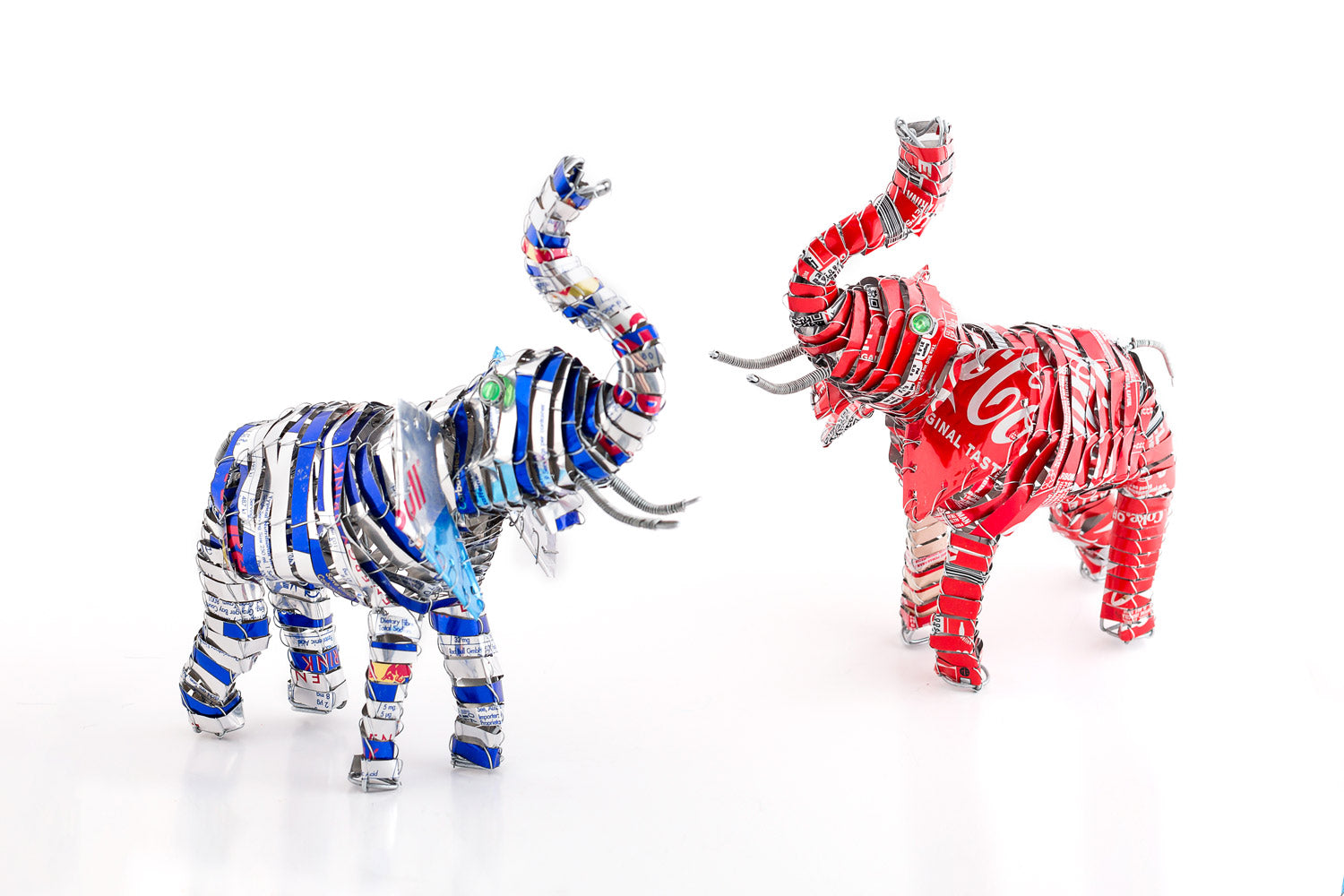 2 Happy Elephants made from recycled tin cans; the first one from Red Bull tins, and the second from Coke tins.  Approx. 8" tall.  Hand made. 