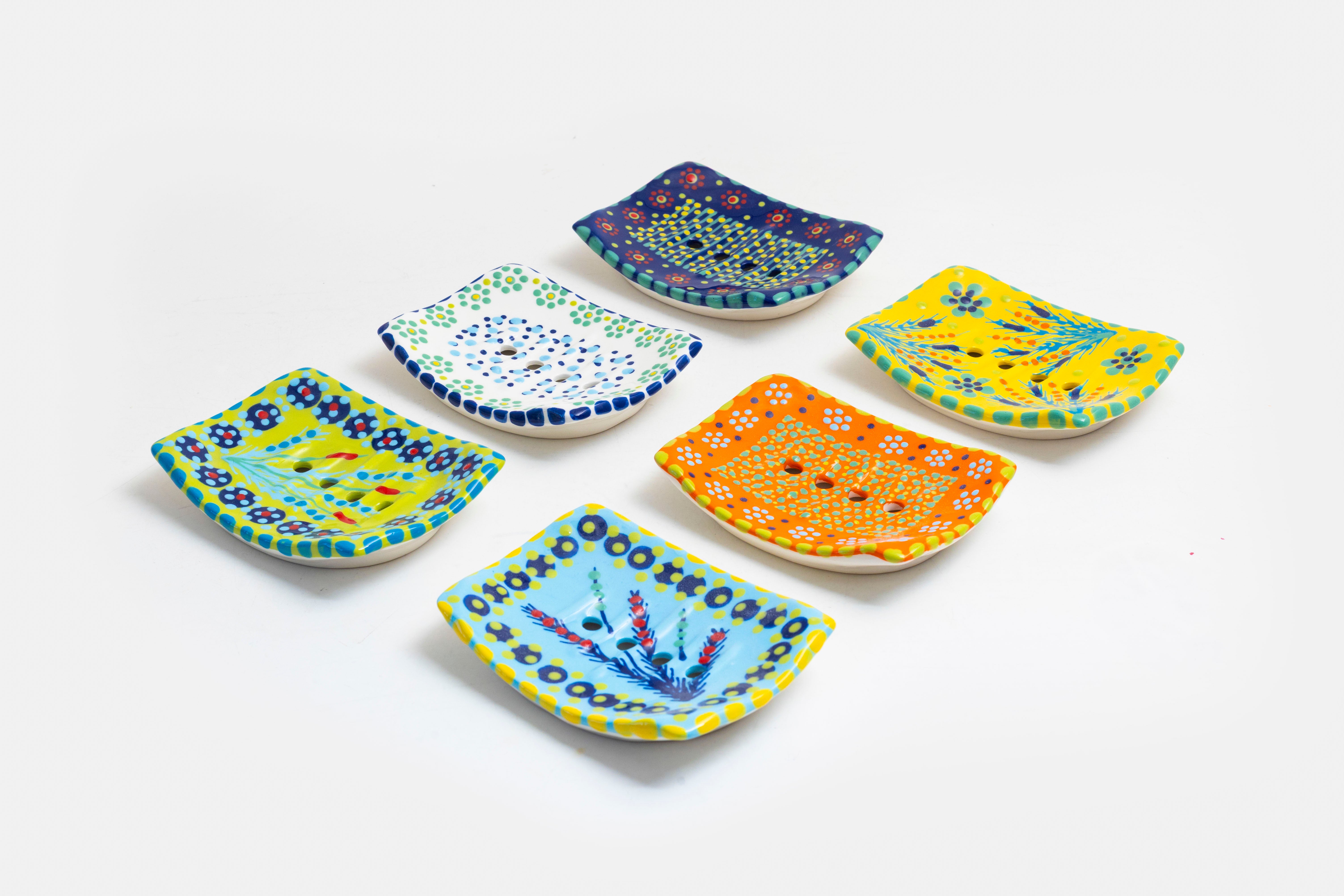 Selection of 6 colorful square ceramic soap dishes with background colors of; lime green, white, indigo blue, yellow, orange, and baby blue. Details painted on in contrasting colors.  So pretty!  AND they have drain holes!