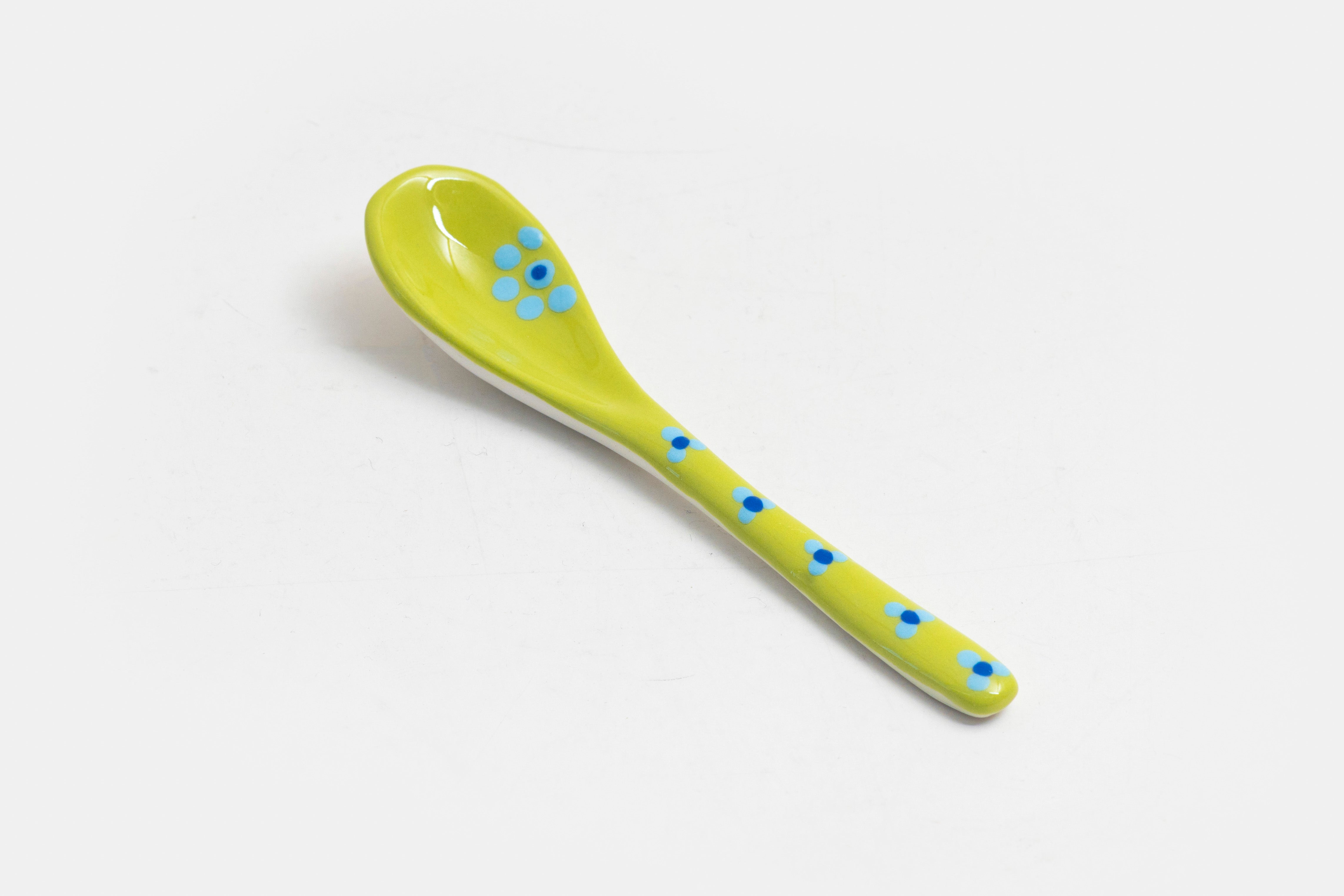 Ceramic small spoon with background color of lime green, detail painted in red, indigo, orange, & baby blue.  Great for condiments. 
