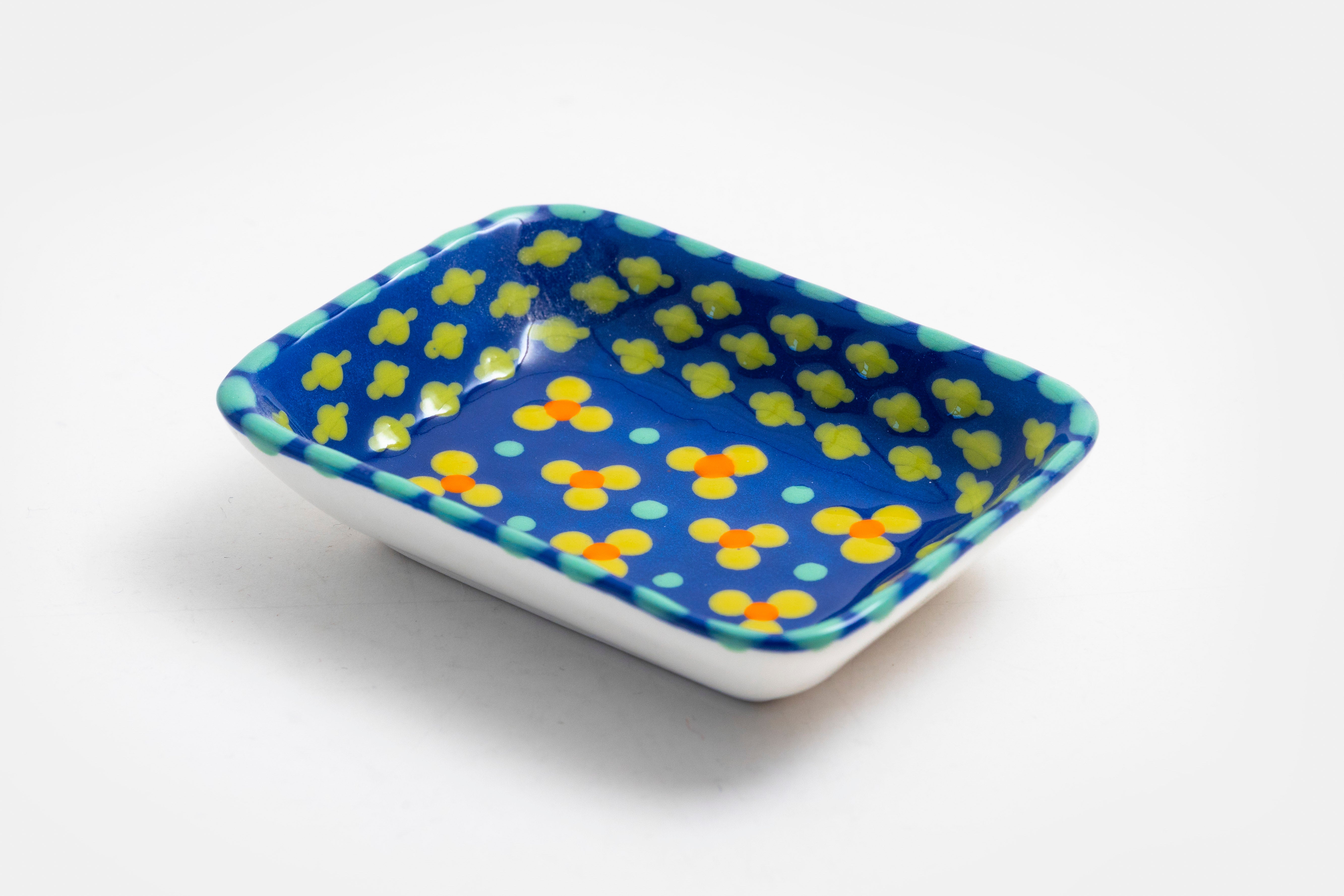 Ceramic rectangle shape Tiny Dish with Indigo base color. Dots & Stripes and flowers painted on top in yellow, red, blue and jasper green.