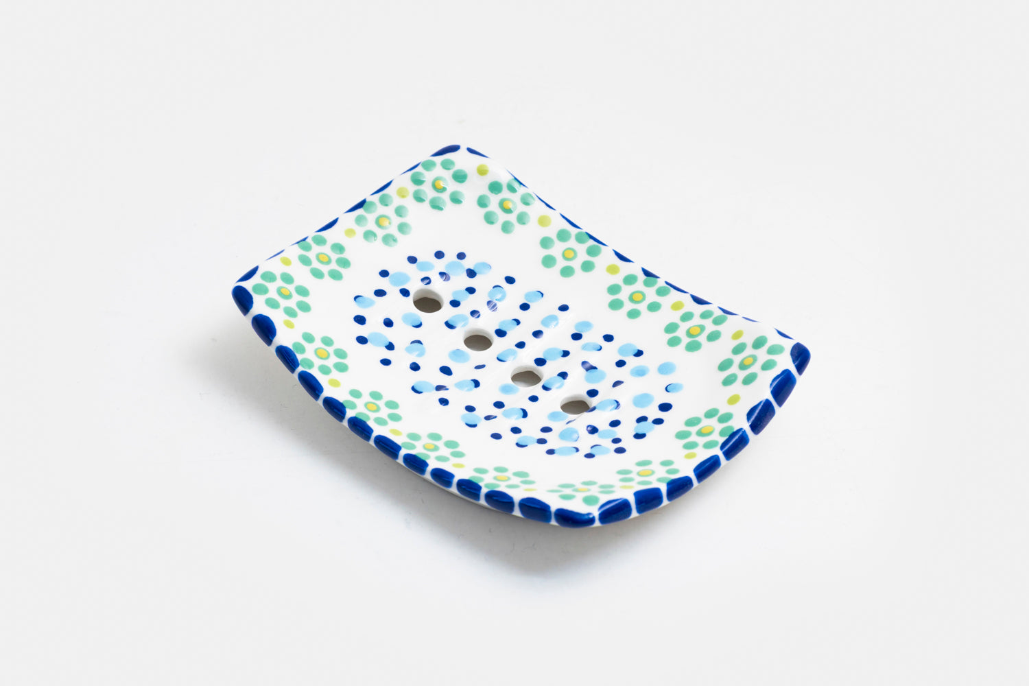 Ceramic square soap dish with base color of white. Flowery design with dots painted on top in lime green, turquoise, red and touches of orange. Drain holes in dish!