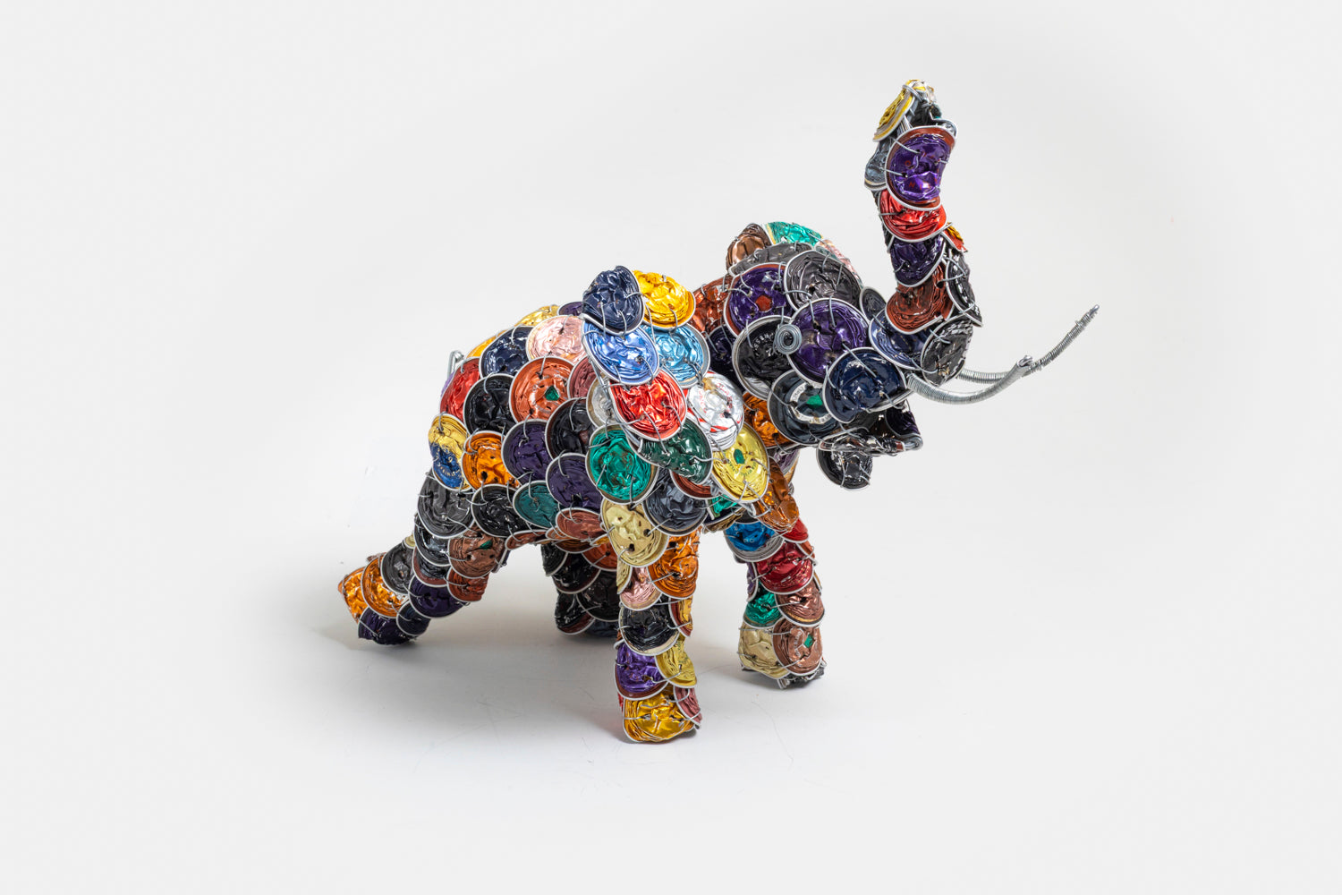 Side view of Elephant made from colorful upcycled coffee pods; cleaned, smashed and strung together to make this wonderful whimsy elephant.  Truck up for Good Luck!