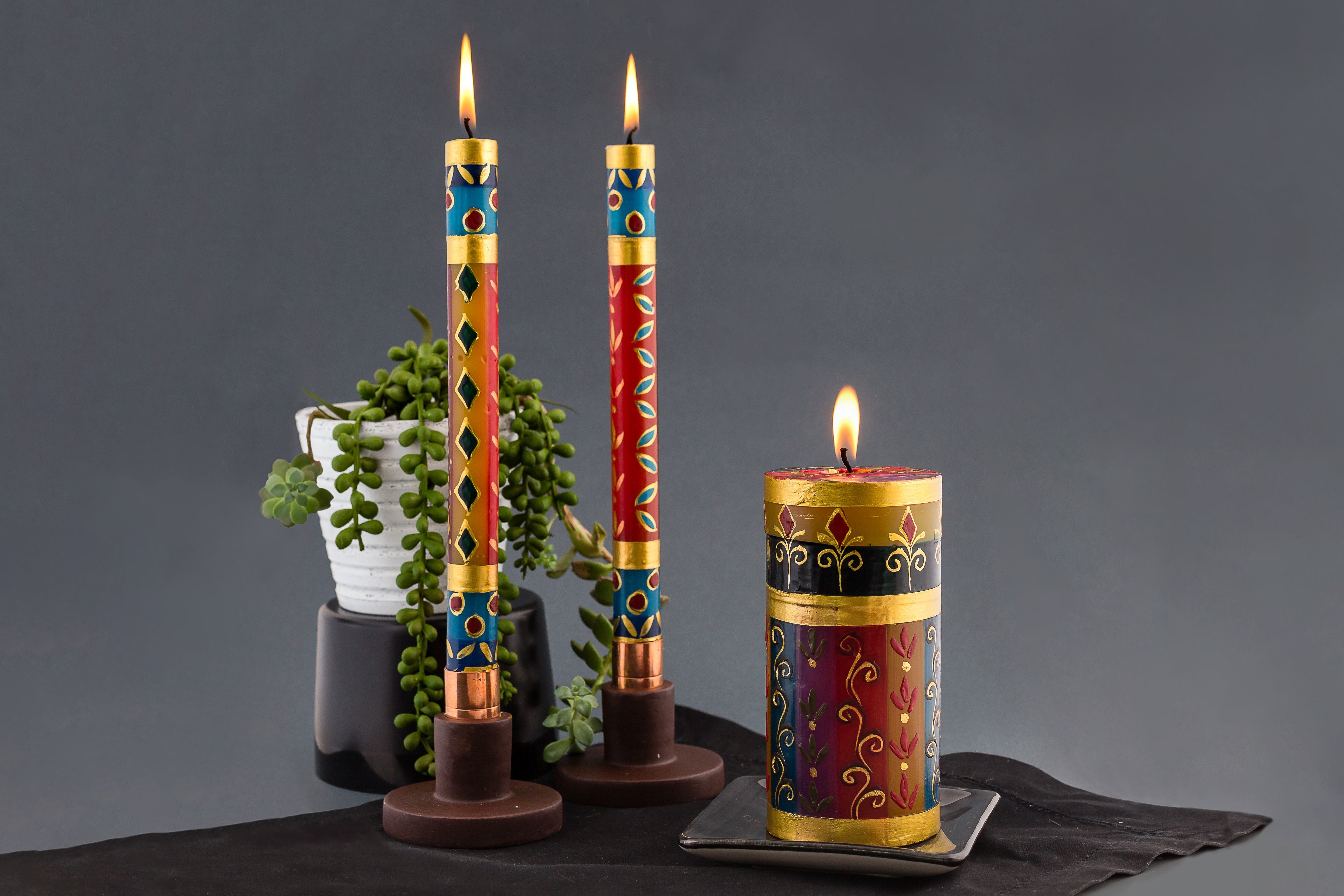 Lifestyle photo of African Mineral dinner tapers and pillar with touches of gold. Fair Trade. Stunning addition to your table!
