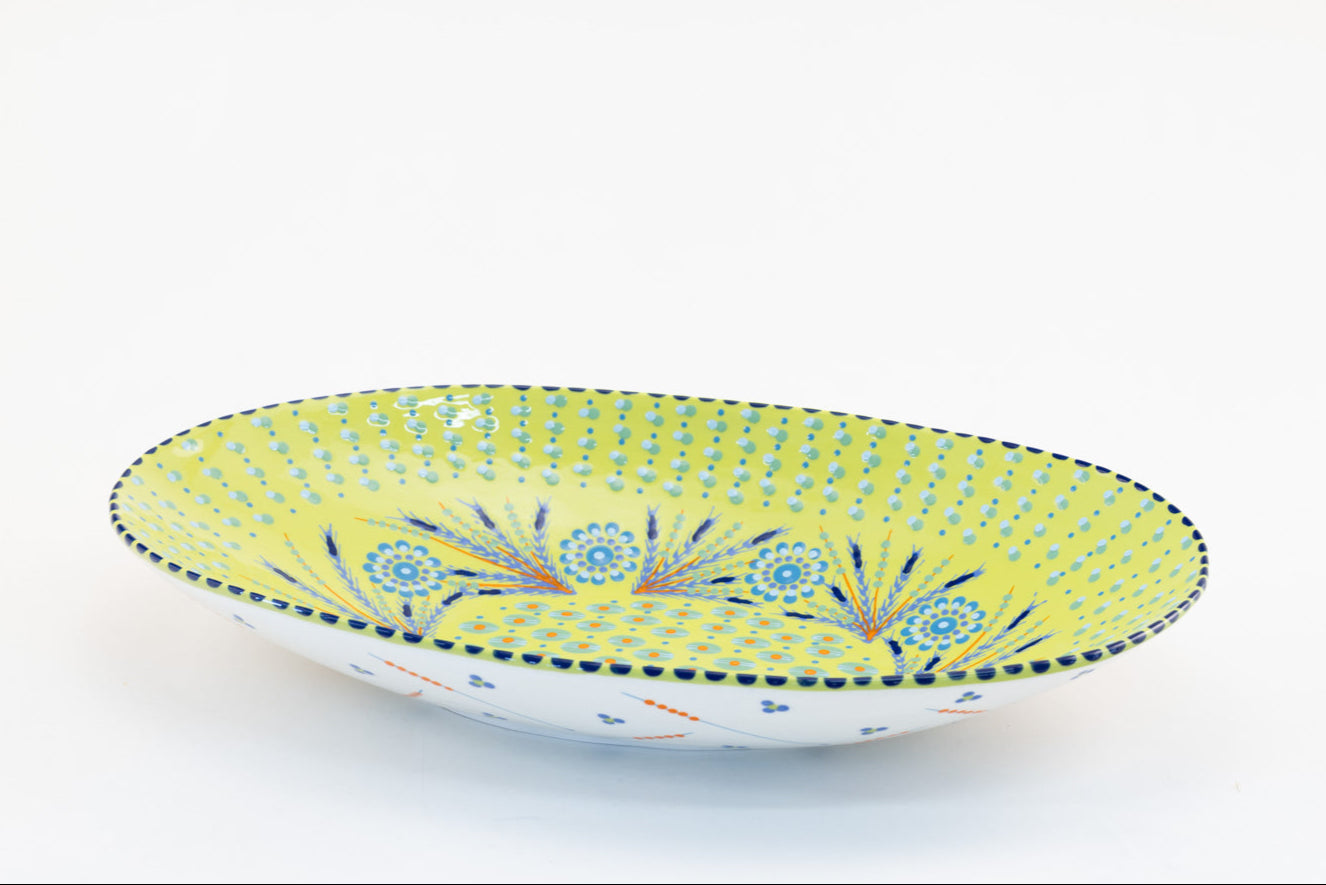 Lime green oval serving bowl with dots, stripes and small flowers painted in baby blue, green and yellow. 15" x 8". Perfect to top off any table!