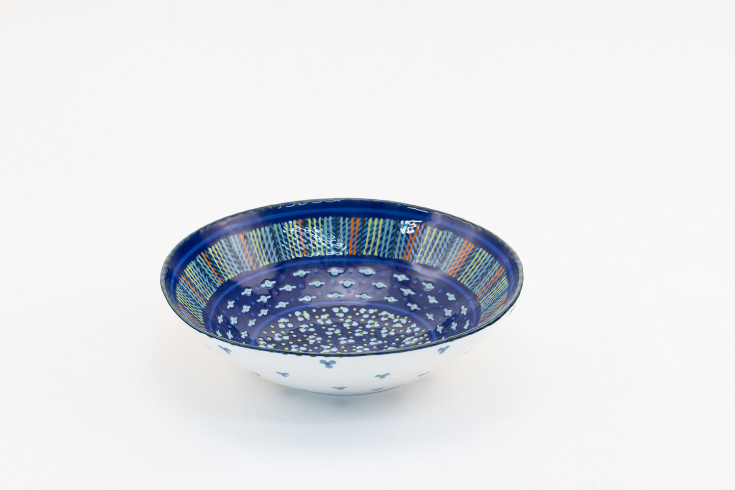 Indigo blue large round ceramic serving bowl. 11"x 3".  indigo background, painted with yellow, green, touches of red, and baby blue.  Microwave & Dishwasher safe.