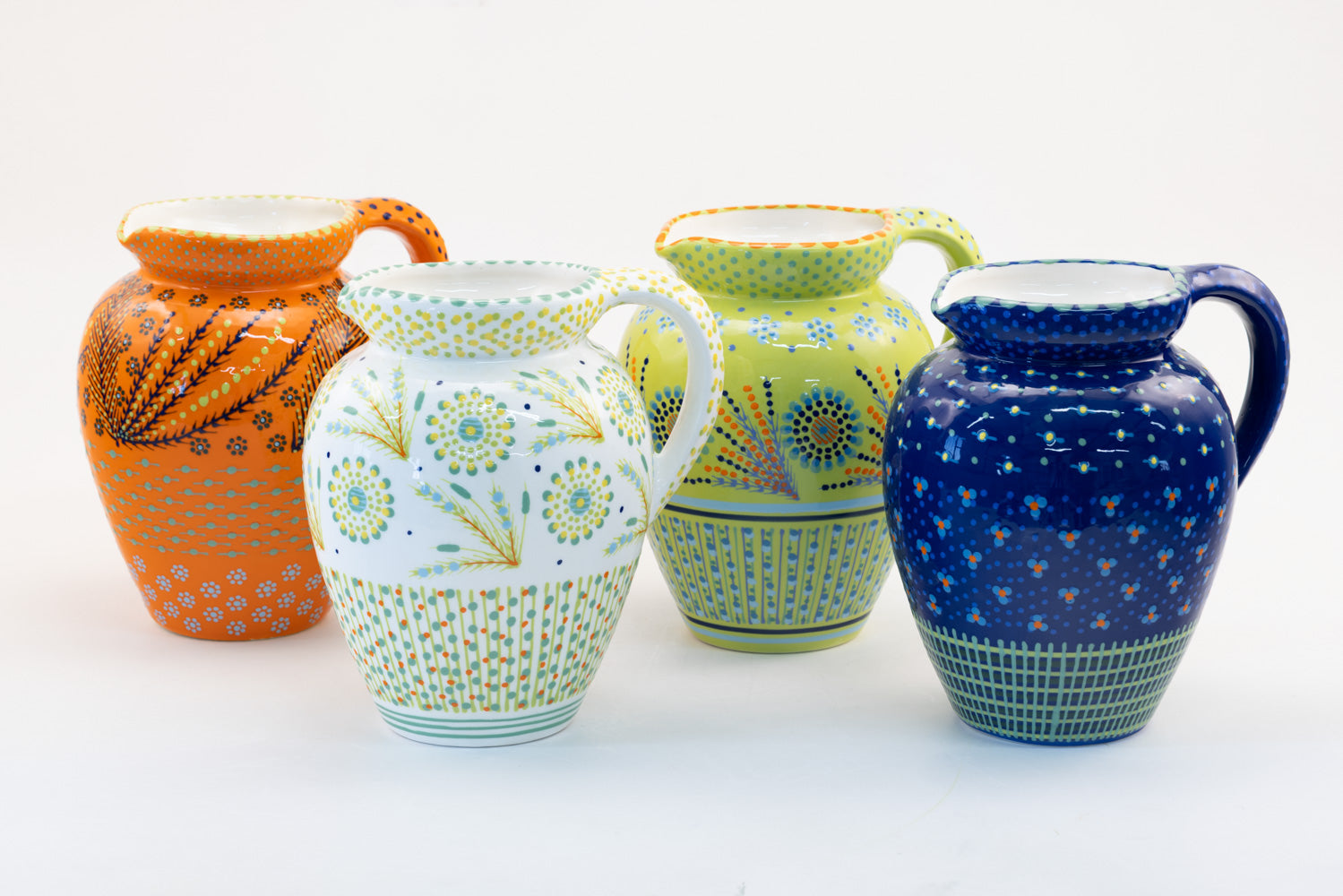 4 fabulous classic water jugs with background colors of lime green, white, indigo blue, and orange.  Dots, stripe and flowers make the colorful designs on the background colors. 9" tall x 5" wide.