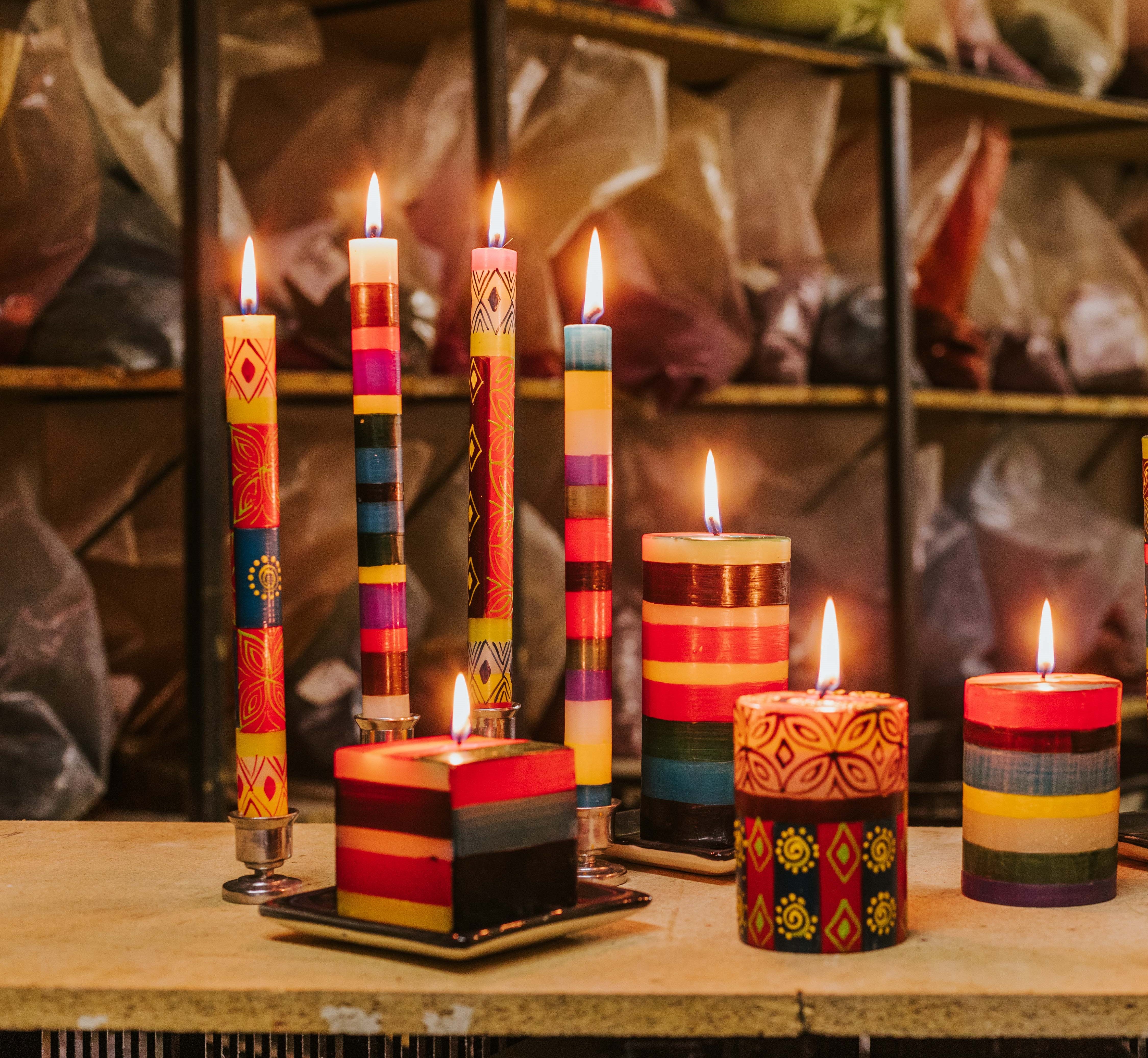 Memphis stripe tapers and pillars along side Desert Rose tapers and pillar.  Illistrates how beautiful the combination of collections can be!  All burning brightly with the bags of candle color powder in the background. 