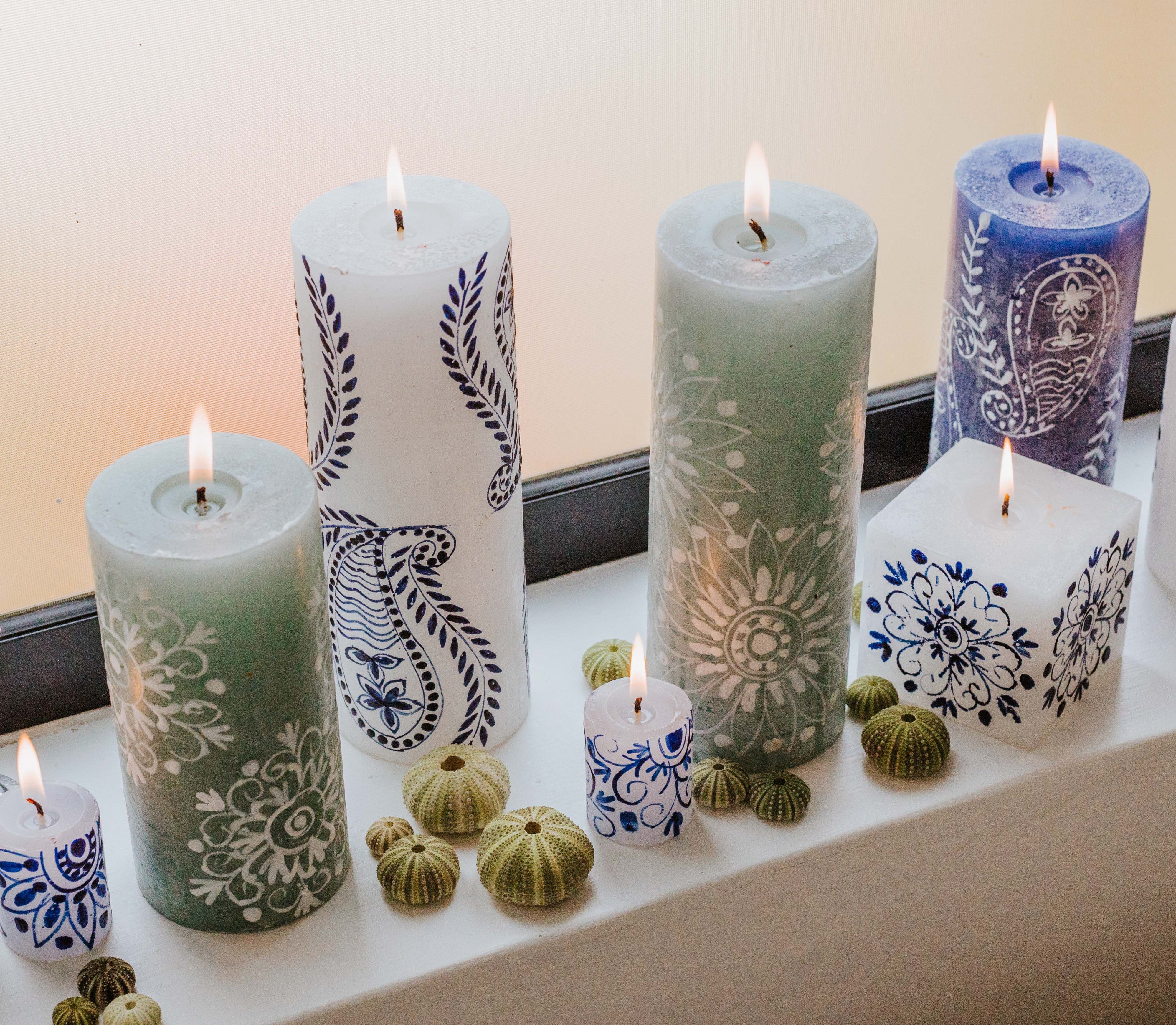 Lifestyle shot of Henna Blue on White pillar, cube and votives with Henna Duck Egg pillars and Henna White on Blue pillar all burning brightly - great to mix and match!