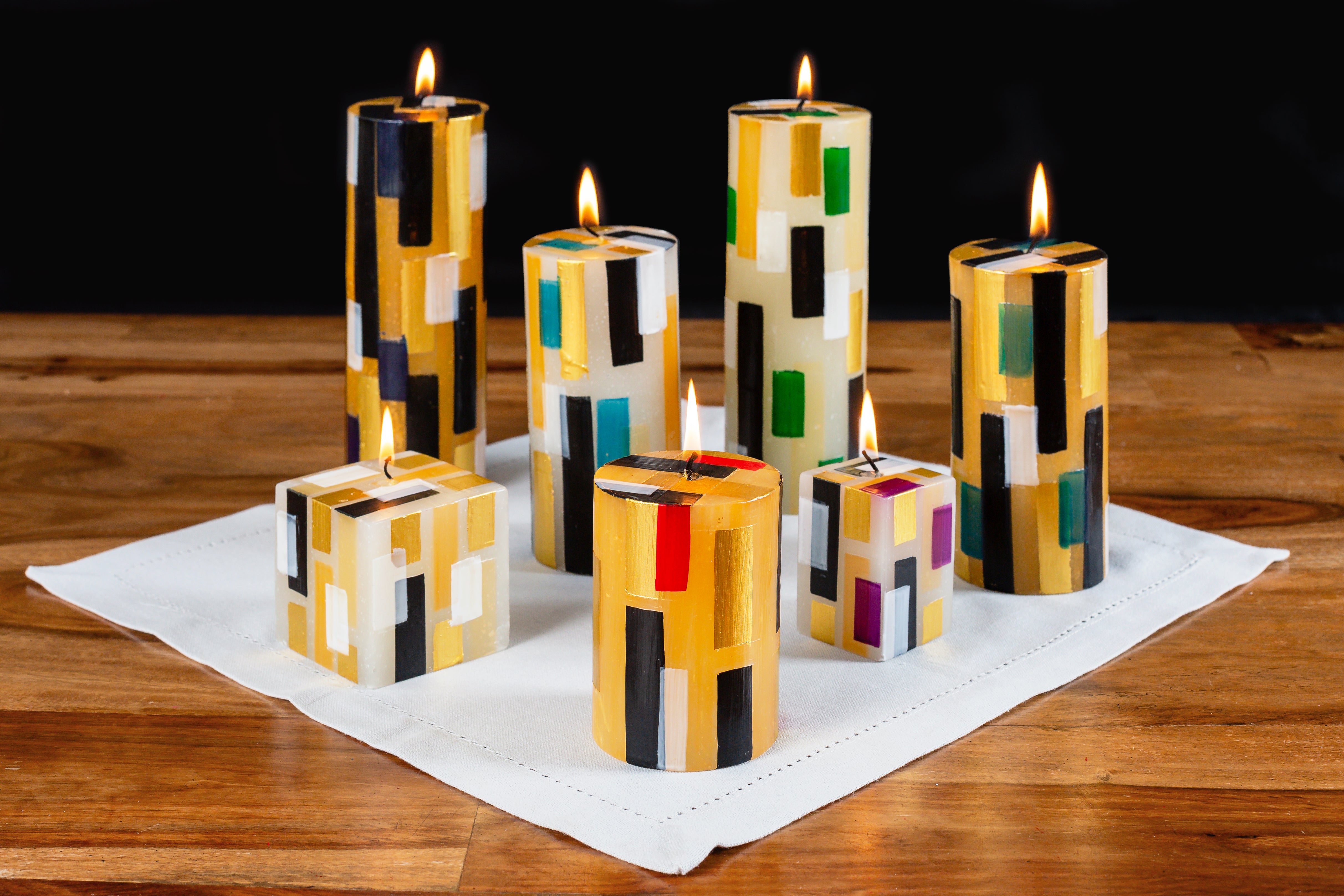 Stunning photo of the Klimt collection Pillar and Cube candles lite on a dinning table. Various sizes. Beautiful contemporary look!