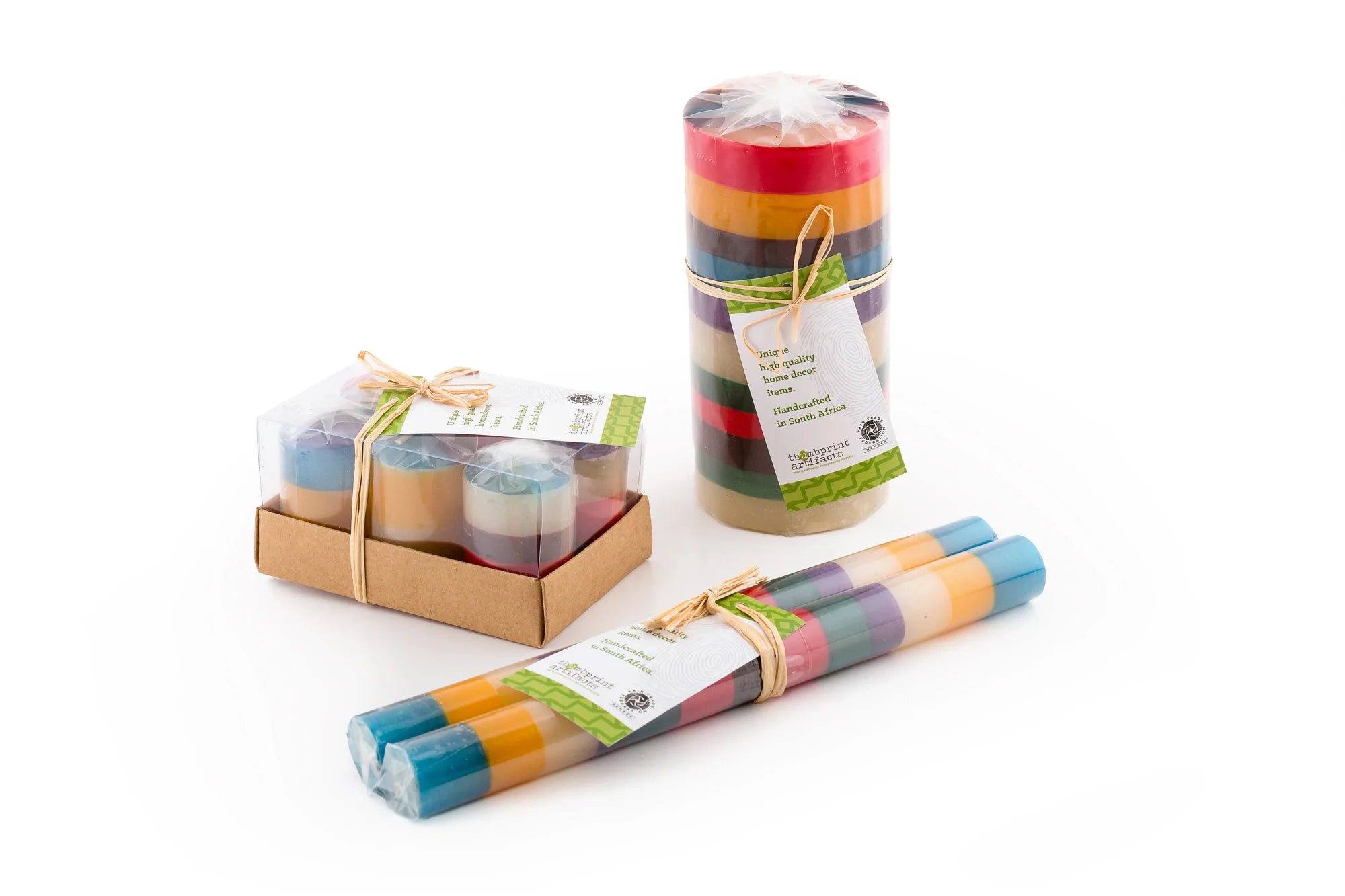 Memphis Stripe candles showing how the candles are packaged. Pillars & cubes are wrapped and tied with story card. Taper pair are individually wrapped and tied together with a story card. Votives are wrapped individually in a 6-pack box. All sustainable packaging.