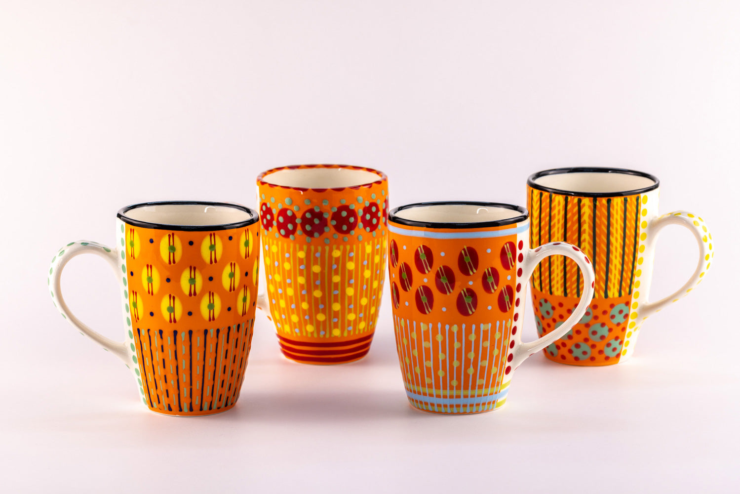 4 Very colorful coffee mugs with Orange base color. Topped with dots & stripes in green, light blue, yellow, and red. Bright & fun!
