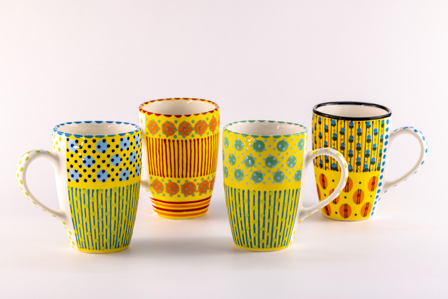 4 Very colorful coffee mugs with yellow base color. Topped with dots & stripes in turquoise, orange, green, light & indigo blue. Very fun!