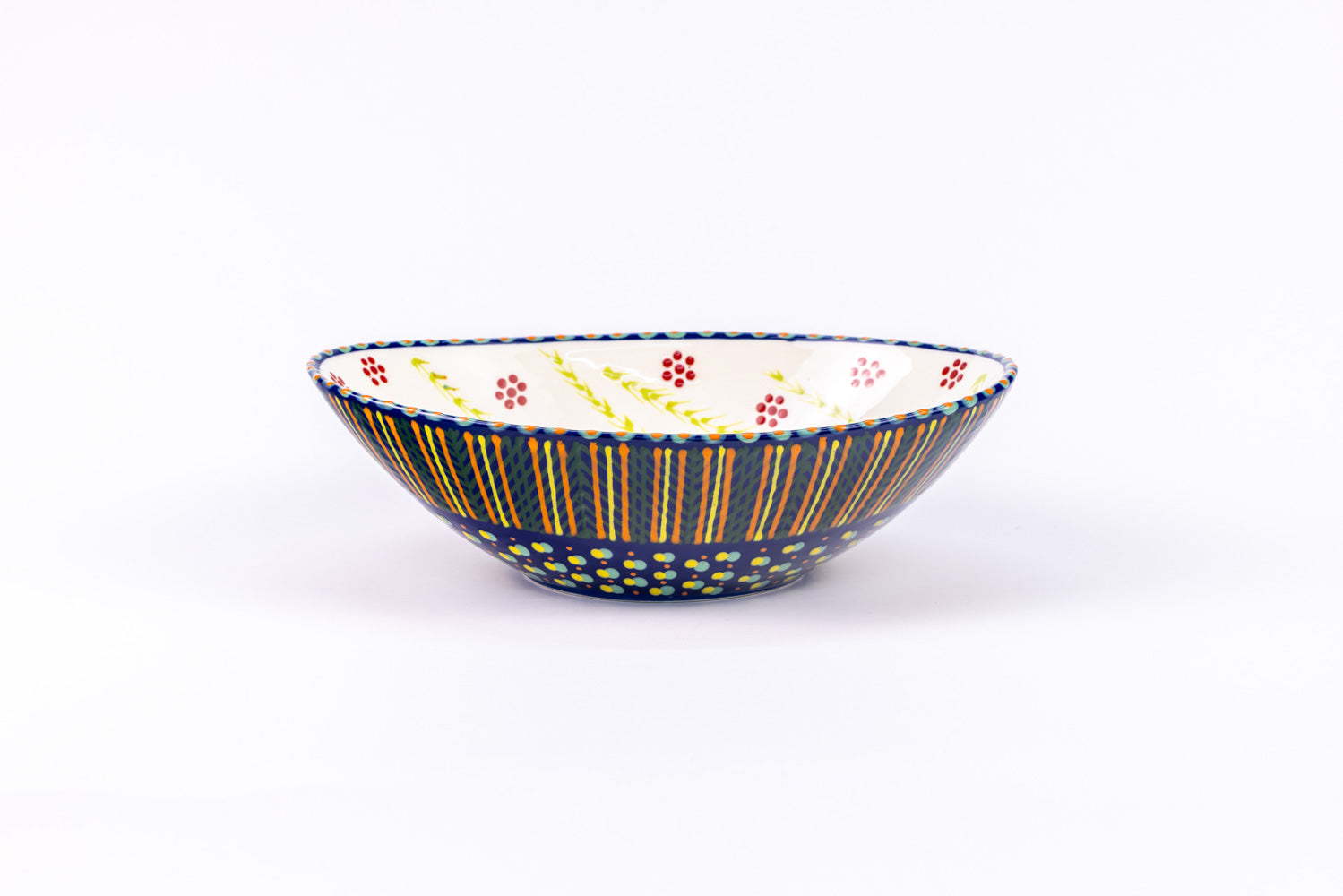 Oval ceramic serving bowl with indigo blue base color. Orange, yellow, and green dots & stripes on top. Inside is white with red 'dot ' flowers and yellow stripe design. Very lovely and fairly traded!