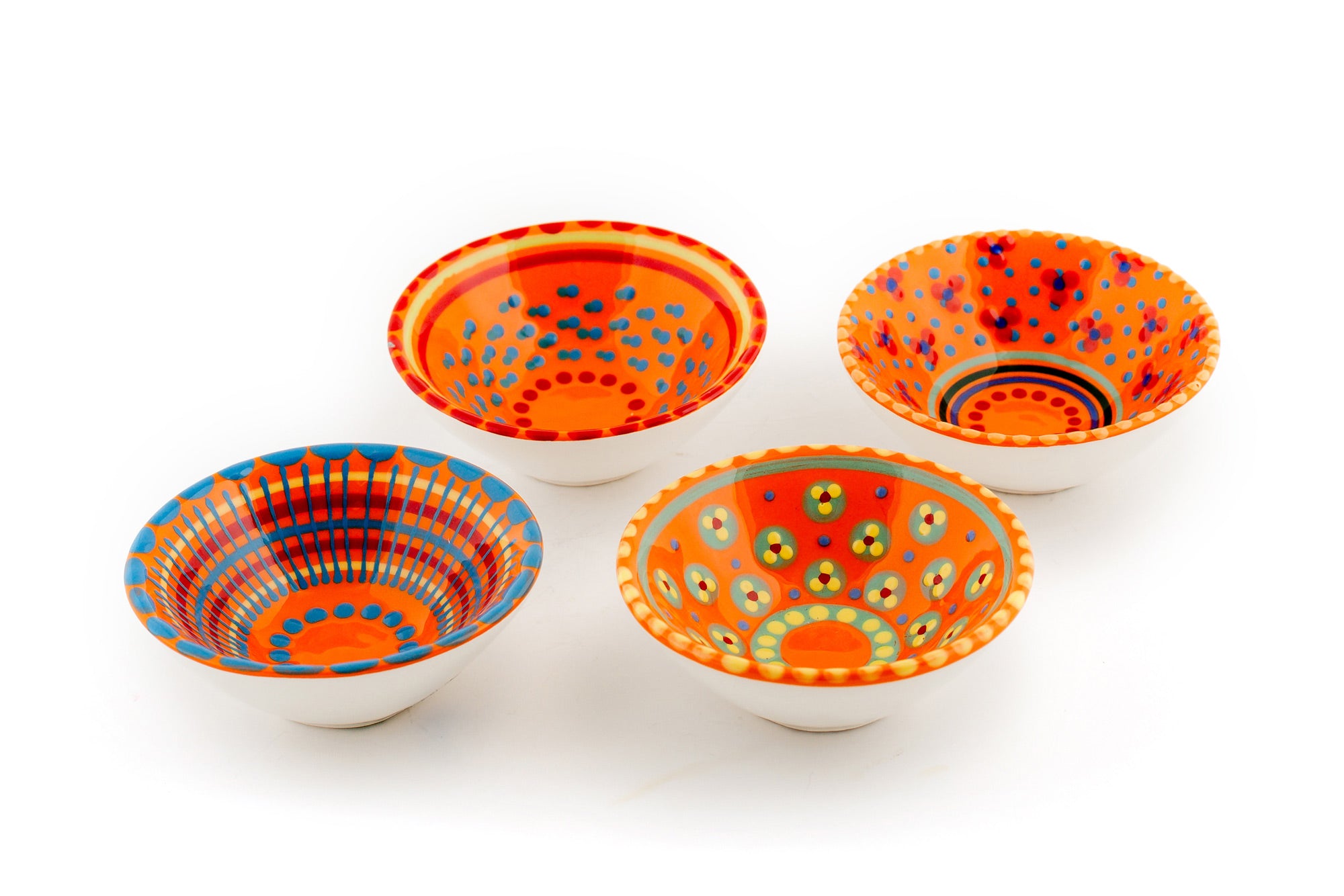 4 Orange tiny bowls. Orango base color with variations of the designs on the blue in rea,  yellow, baby blue and jasper green.