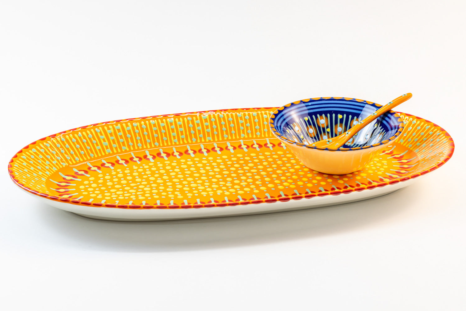Ceramic serving platter in Orange with Indigo Blue mini nut bowl & Orange small spoon sitting on the platter. Perfect size for condiments and beautiful color contrasts.