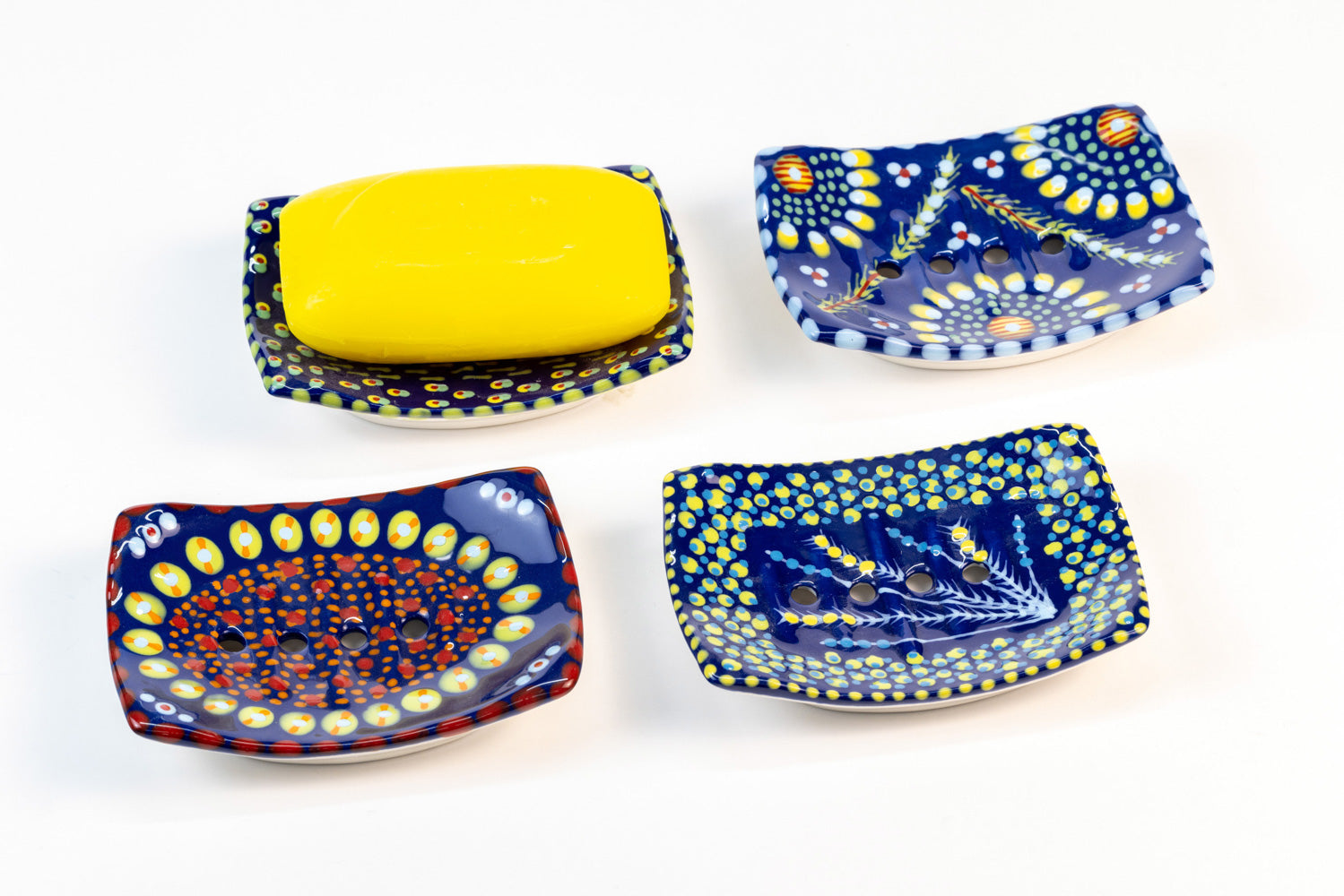 Ceramic square soap dish with base color of Indigo Blue. Flowery design with dots painted on top in yellow, turquoise, red and touches of orange. Drain holes in dish!