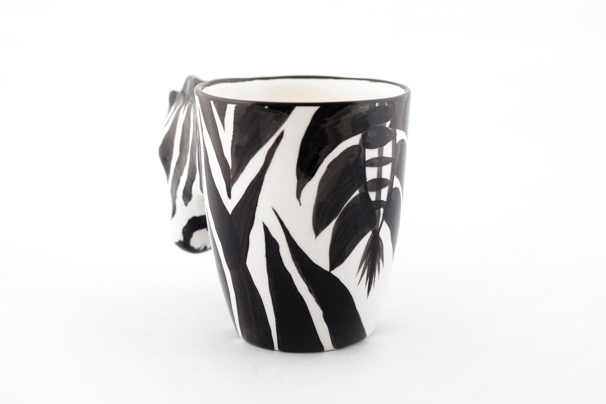 Back side of the ceramic Zebra coffee mug. White mug painted in zebra print with a zebra head for the handle and the back side shows the tail painted on the mug. Attention to detail!