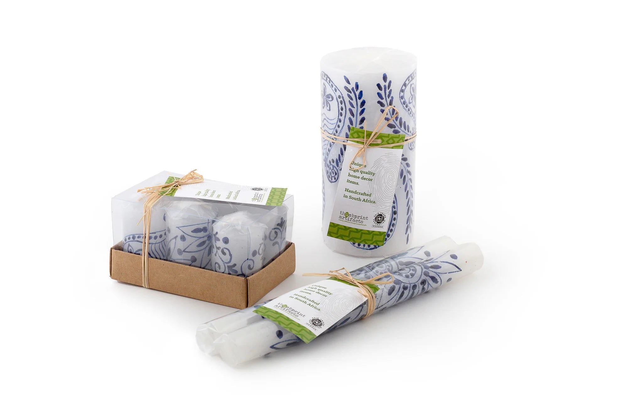 The photo shows the packaging of the Henna Blue on White candles.  Votive 6-pack tied with story card, pillar & cube wrapped in cello paper and tied with a story card, matched pair of tapers wrapped in cello paper and tied with a story card.