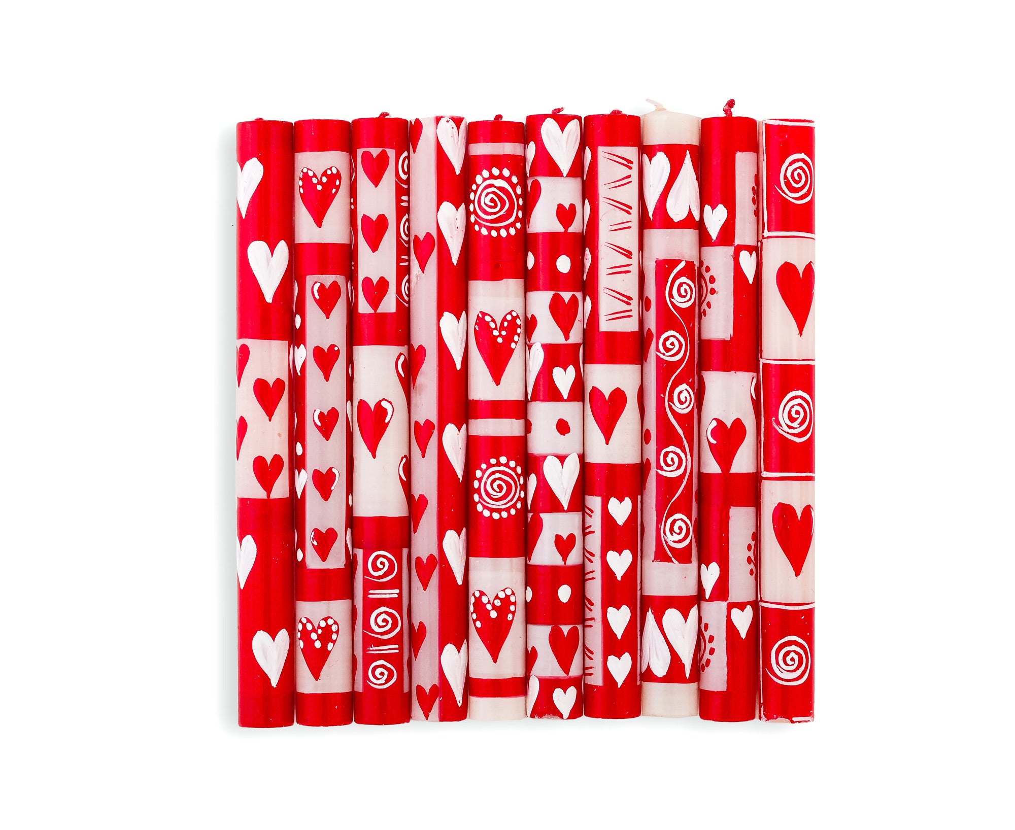 Valentines hand painted candle collection.  Red & white  with whimsy hearts, dots, and circle graphics.  Photo shows the 10 designs in the collection on 9" taper candles. Fair trade home decor.