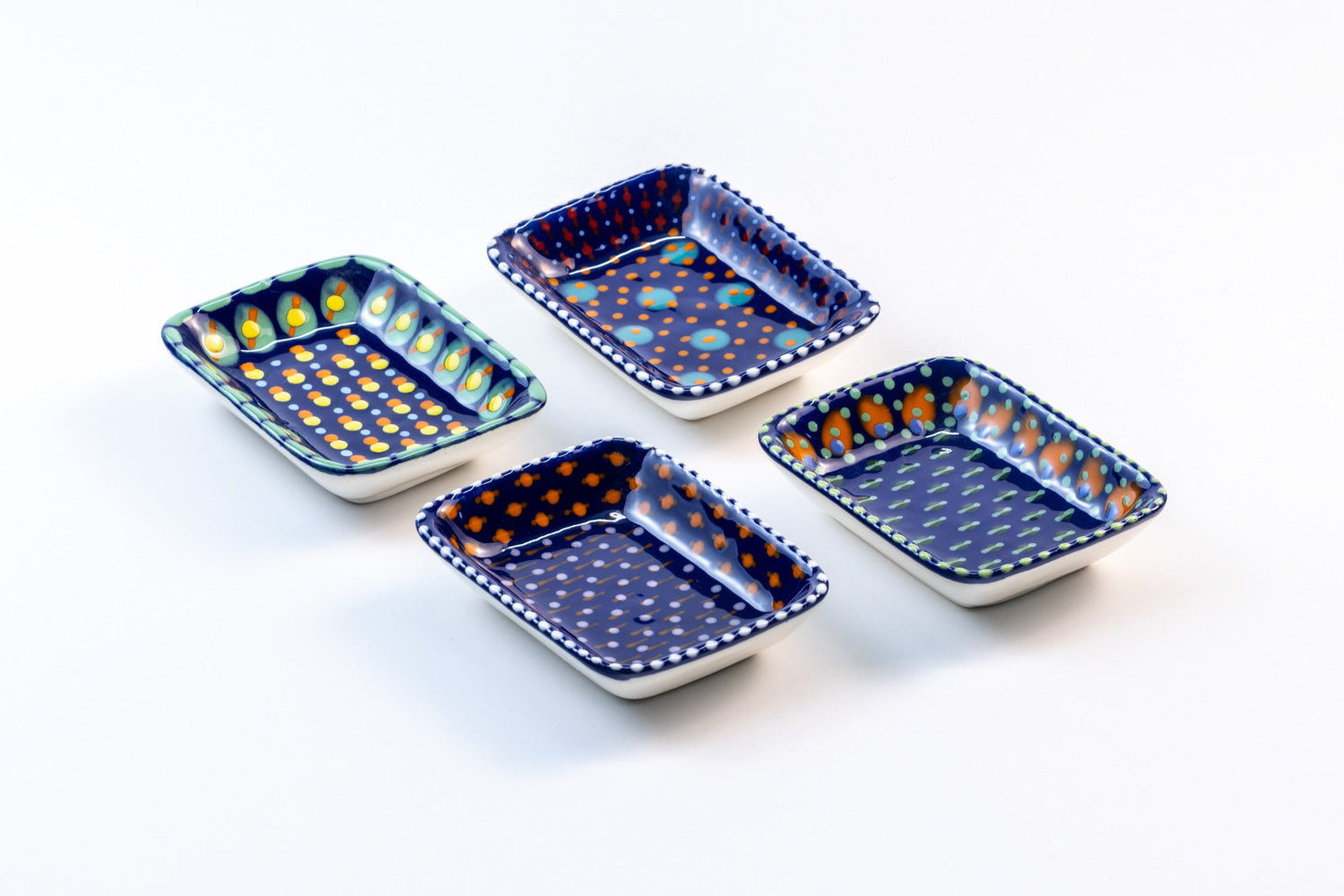 4 ceramic rectangle shape Tiny Bowls with Indigo blue base color. Dots & Stripes painted on top in yellow, red, orange and jasper green.