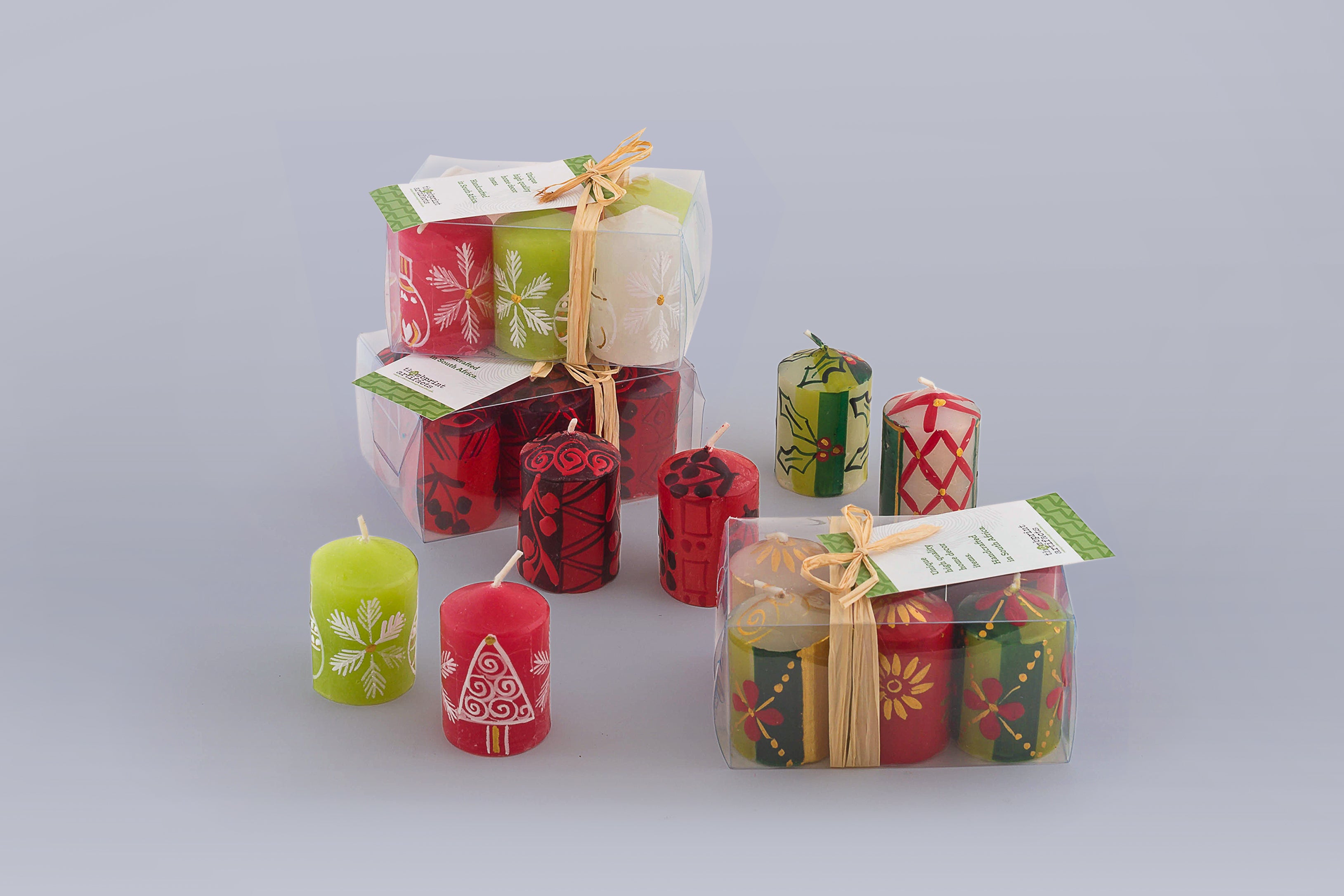 Votive 2" candles in Whimsy Christmas, Berry Blaze, and traditional Christmas to show that they look great together - so mix and match! The photo shows the presentation of the 6-pack box with story tag.