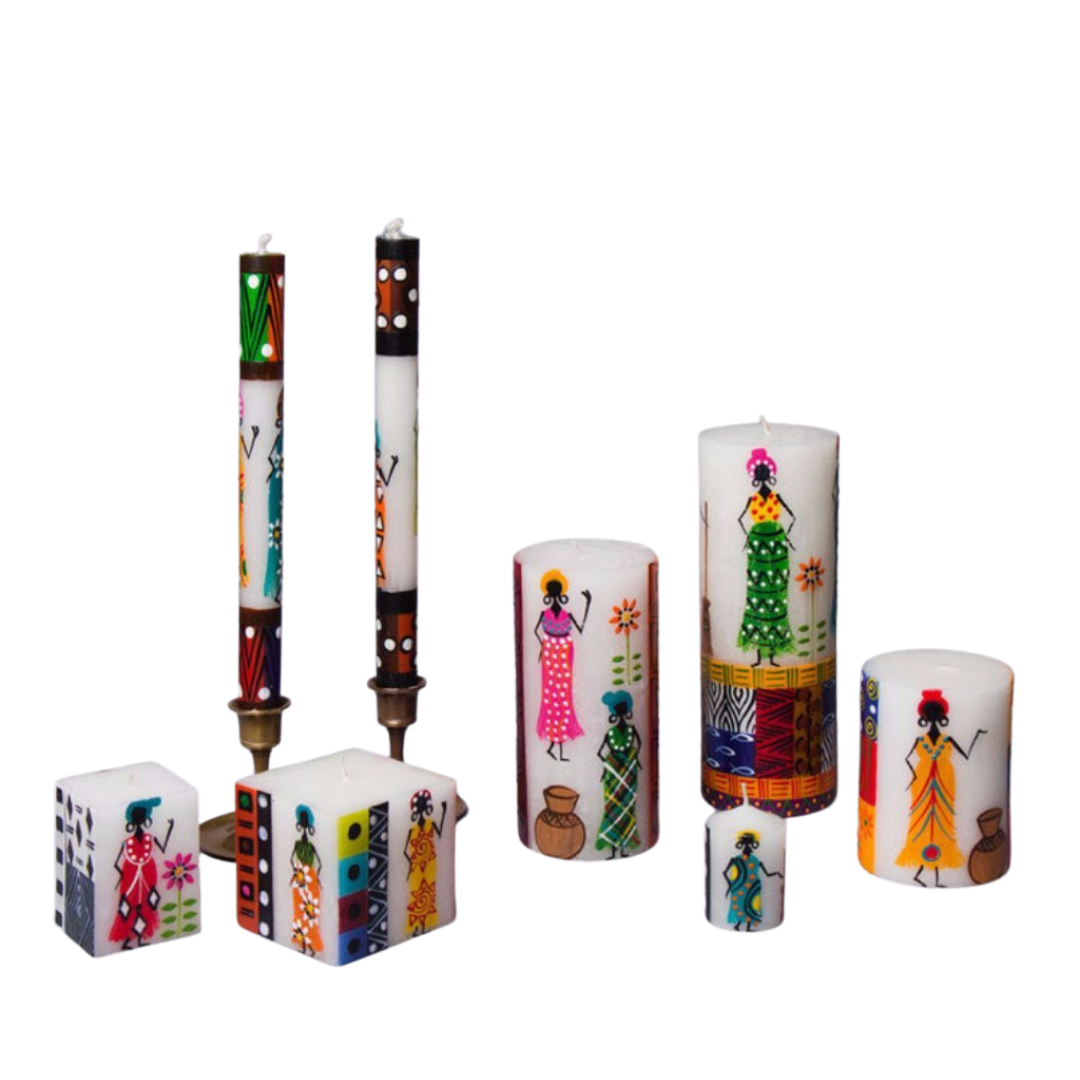 The African Ladies collection of hand made candles.  Small cube, larger cube, tapers, pillars in 3 sizes, and votive. The design has a white background with different African Ladies painted on the sides - with attitude! Each in a colorful frock with arm up or on hips. Fair Trade.
