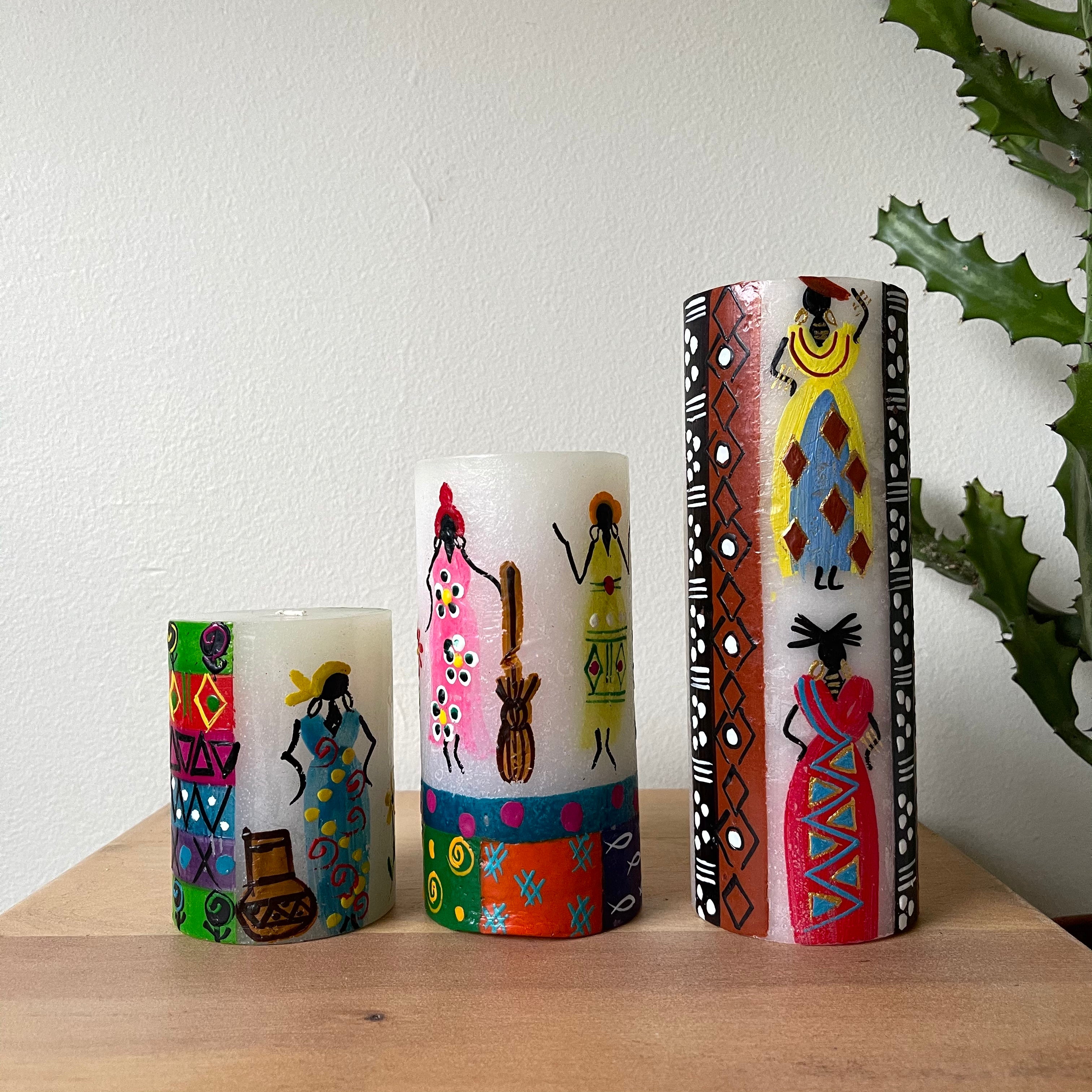 Three African Ladies pillars; 3x4, 3x6, 3x8.  Each with colorful design and whimsy African Lady painted on the side. Fair Trade