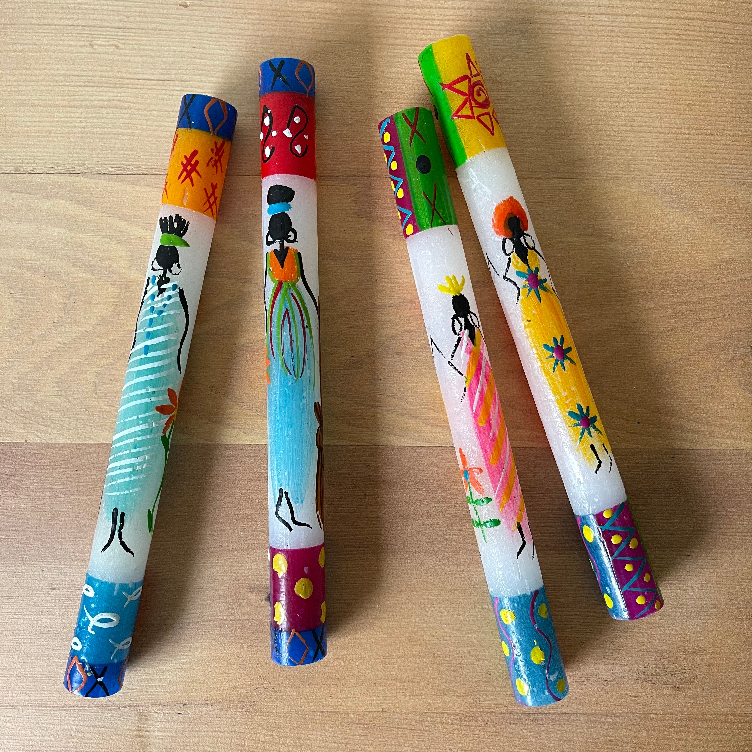 Two pairs of African Ladies tapers.  Colorful design at the top and bottom of each taper, with a whimsy African Lady painted on the side of the candle. Fair Trade.