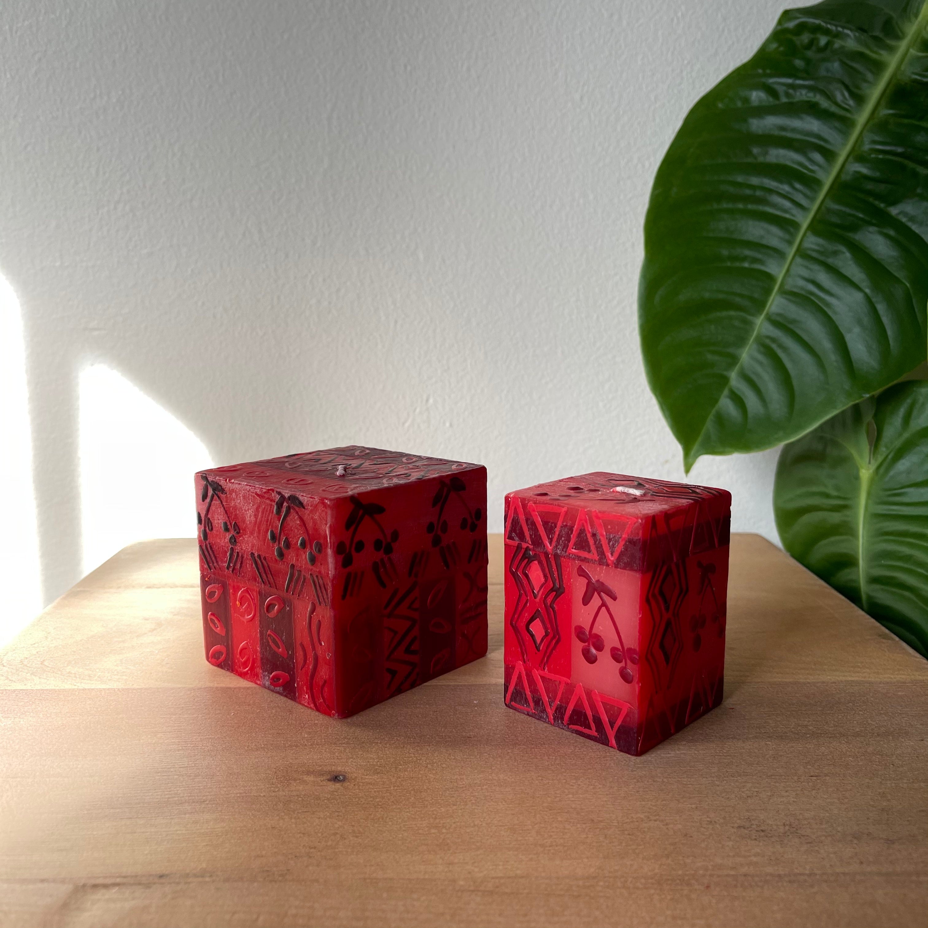 Two Berry Blaze cube candles, 3x3x3 and 2x2x3.  Hand made in hews of red with berry pattern.  Fair Trade candles.