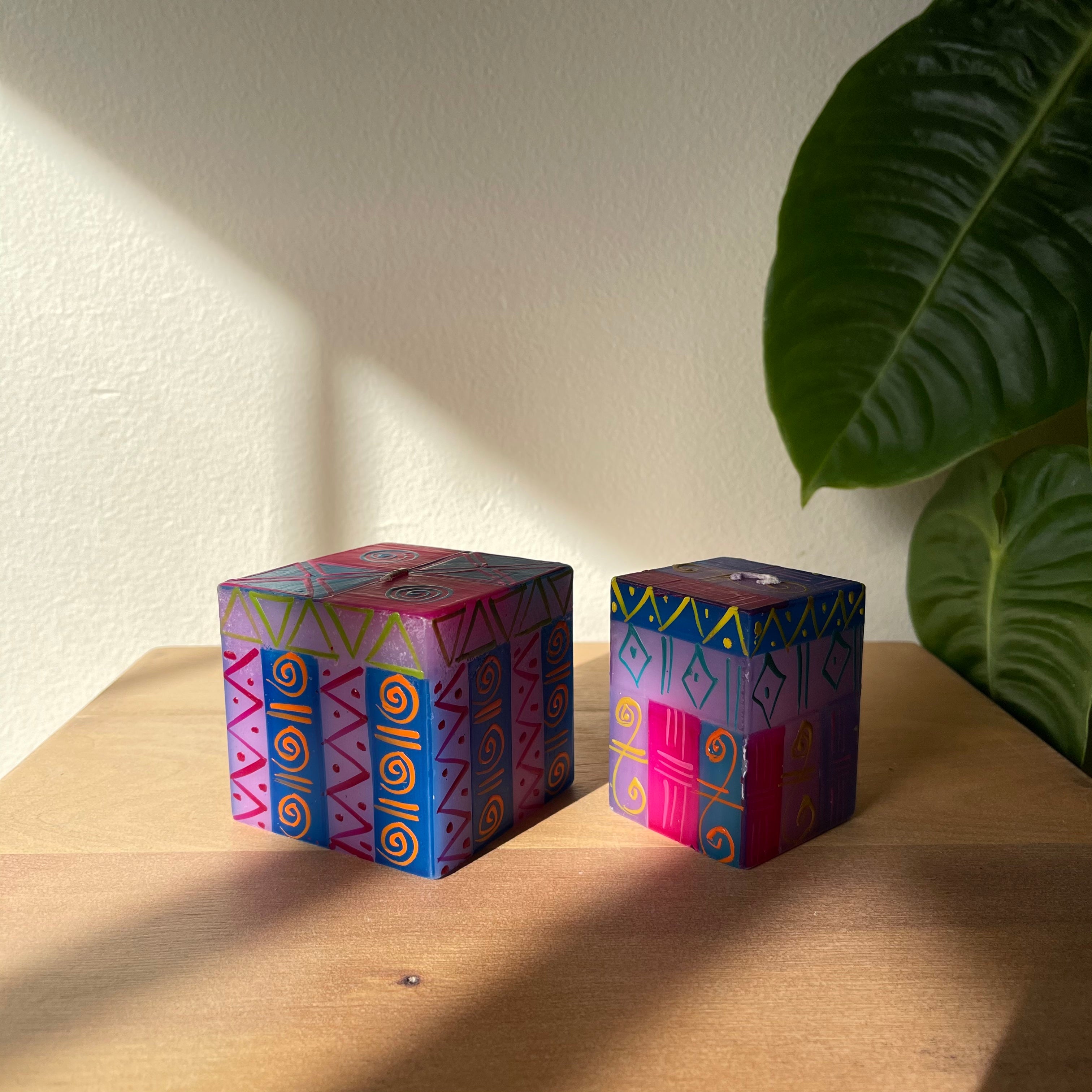 Two Blue Moon candle cubes, 3" x 3" x3" and 2" x 2" x 3".  Both hand painted in the Blue Moon pattern; hews of blue, red, yellow, and pink.