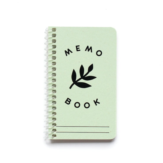 Small memo book with spiral binding.  Light green color with Memo Book printed in black and an image of a leaf in black.