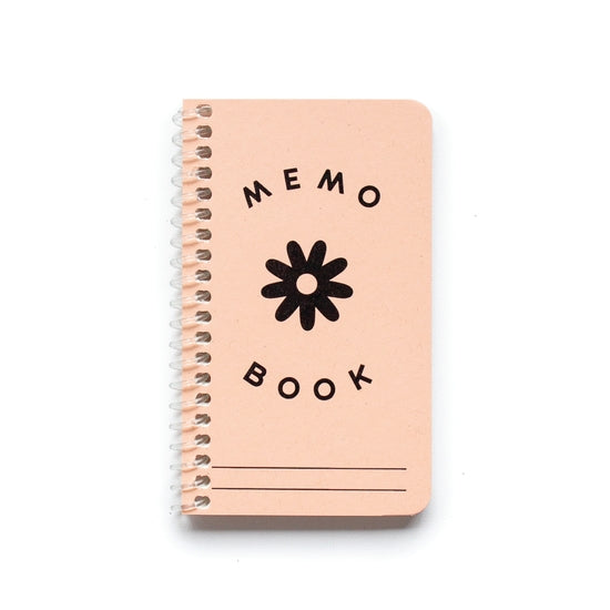 Small memo book with spiral bind and light pink cover.  Printed in black in Memo Book and a flower.