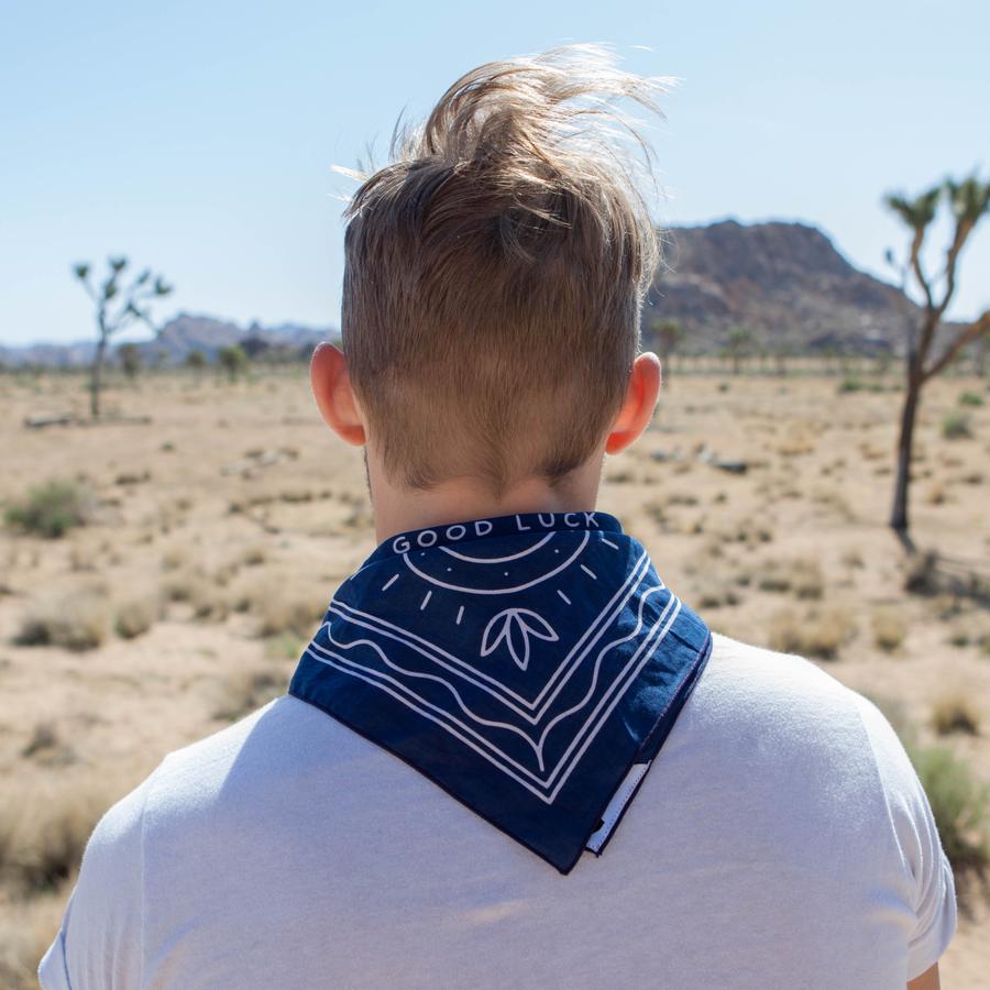 Man showing how the bandana can be worn around the back of the neck showing the message 'Good Luck'.