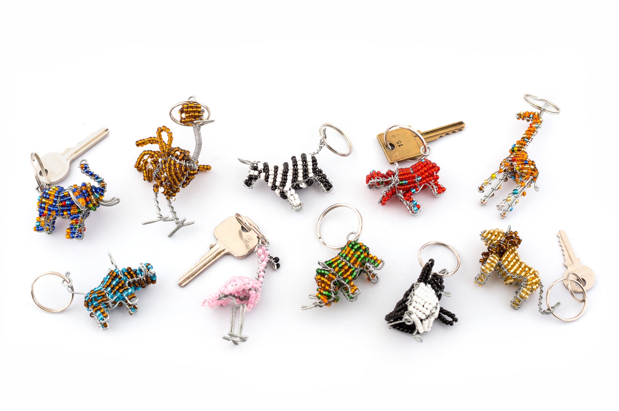 Group shot of African Animal key chains. All handmade in colorful selection of beads.  Elephant, ostrich, zebra, hippo, giraffe, warthog, pink flamingo, rhino, pengiun, & lion.  Fair trade products.