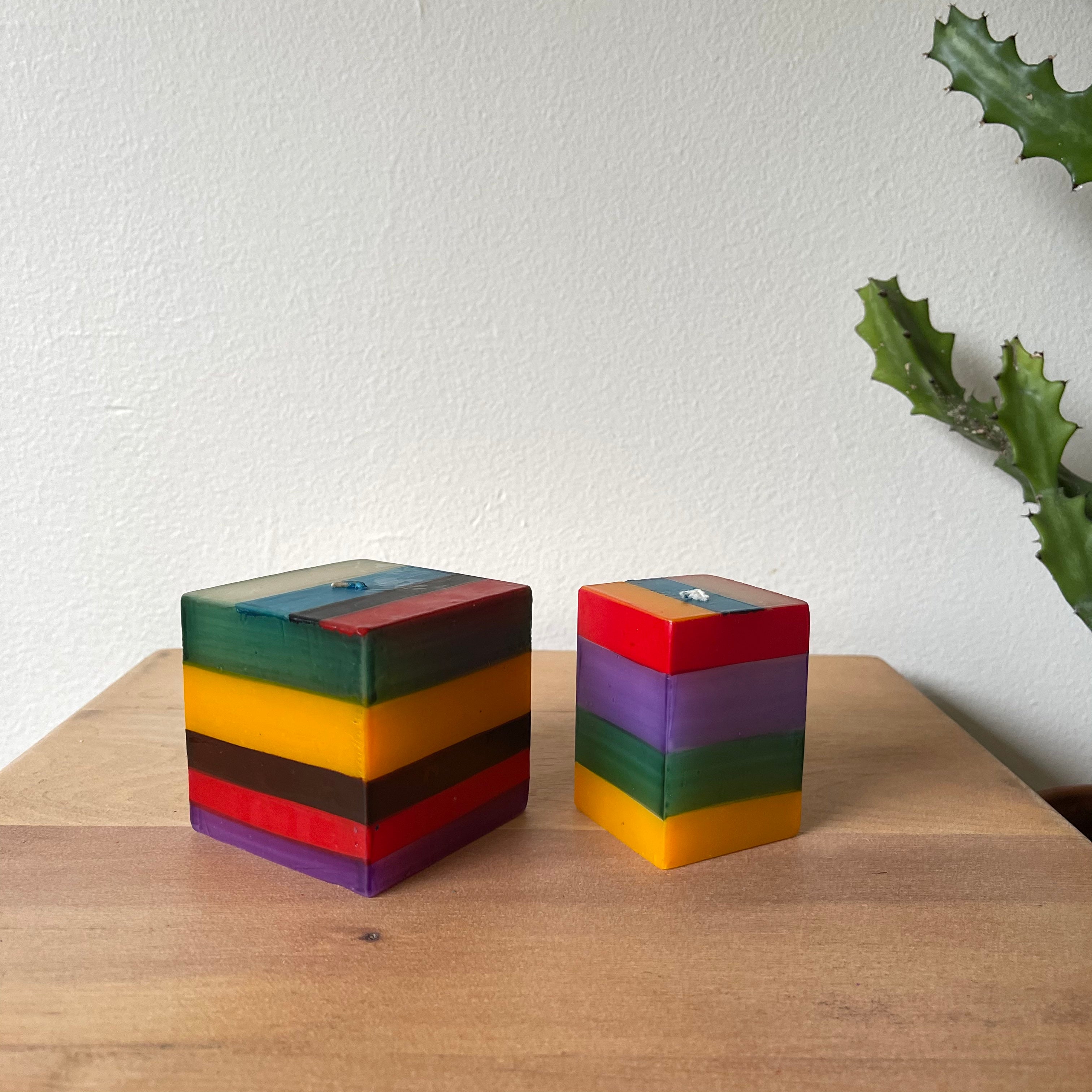 2/ Memphis Stripe cube candles.  3x3x3 cube candle and 2x2x3 cube candle.  Painted in stripes of green, yellow brown, red and purple.  
