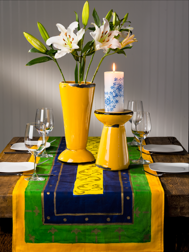 Table setting with a Hand Painted Table Runner in royal blue, yellow and green call Renaissance.  Fair Trade product
