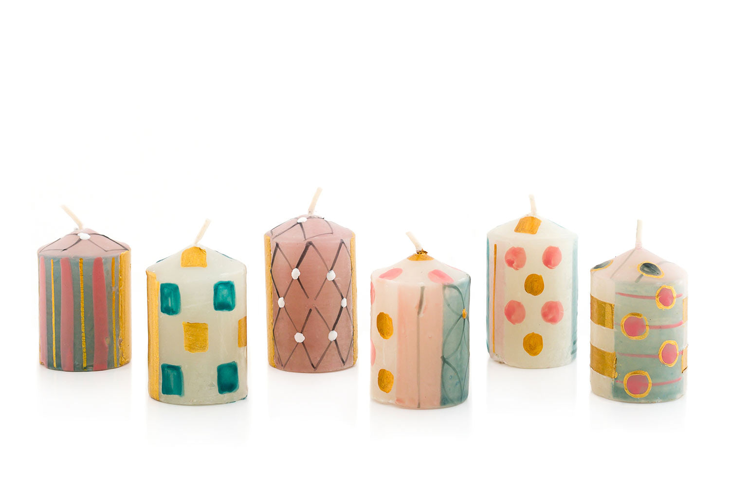 Delight hand made and hand painted collection of votive candles.  6 votive candles in various design of Delight collection painted in pinks, gold, turquoise, on white background.