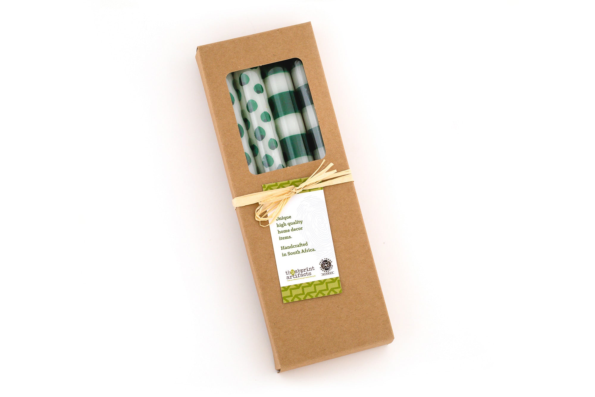 Four white tapers, two with dark green dots and two with dark green stripes, wrapped in celo, in a kraft brown gift box, tied with story card.
