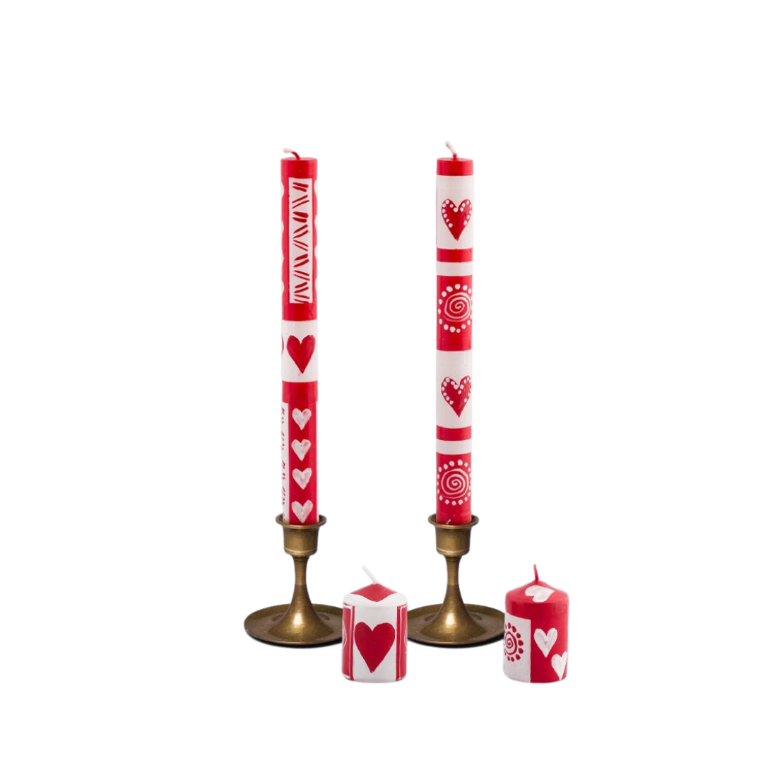 A pair of Valentines taper candles in gold taper candle holders with 2 Valentines votives in front. The candles are hand made and hand painted with red & white whimsy designs and fun hearts!