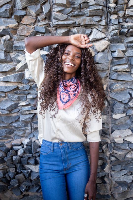 The woman who designed the bandana wearing it around her neck. 