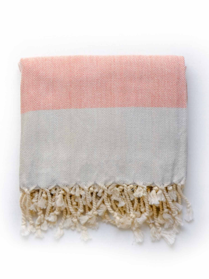 Rust red/grey linen blend Turkish towel folded with tassels on the edge.