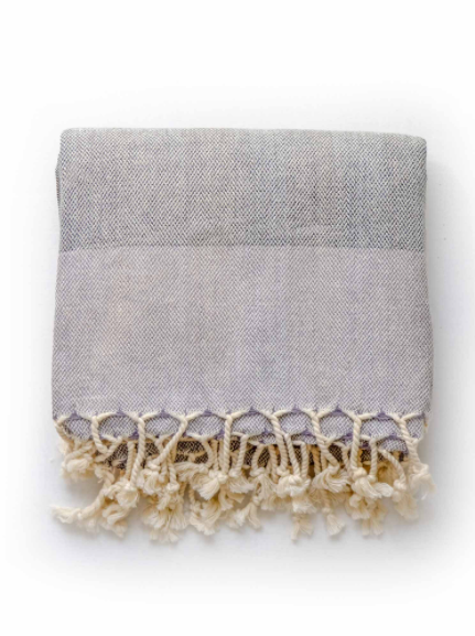 Black/grey linen blend Turkish Towel folded with tassels on the edge.